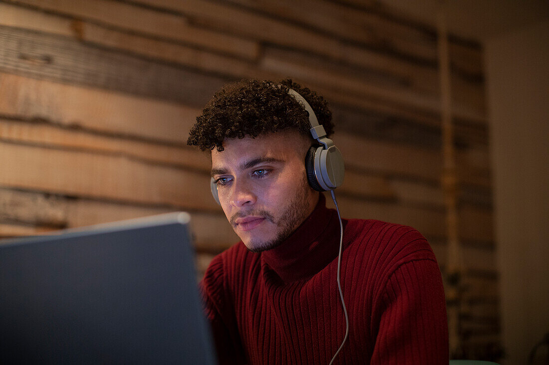 Focused young man with headphones using digital tablet