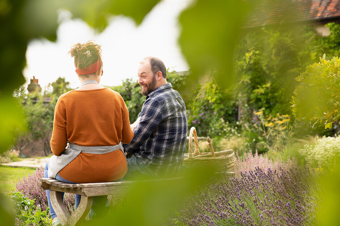 Happy couple taking a break from gardening in backyard