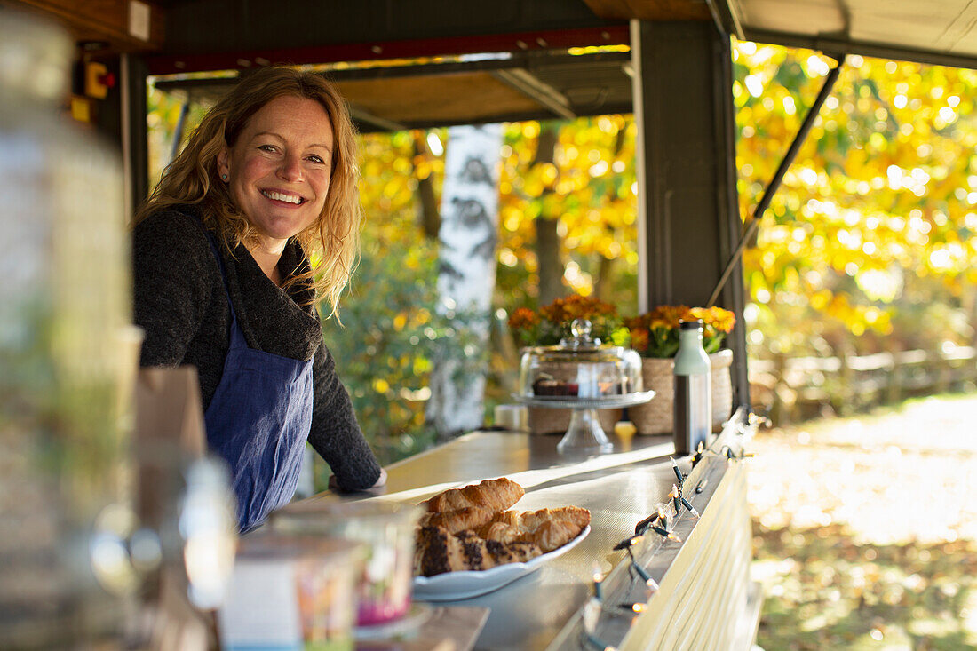 Happy female food cart owner working in park