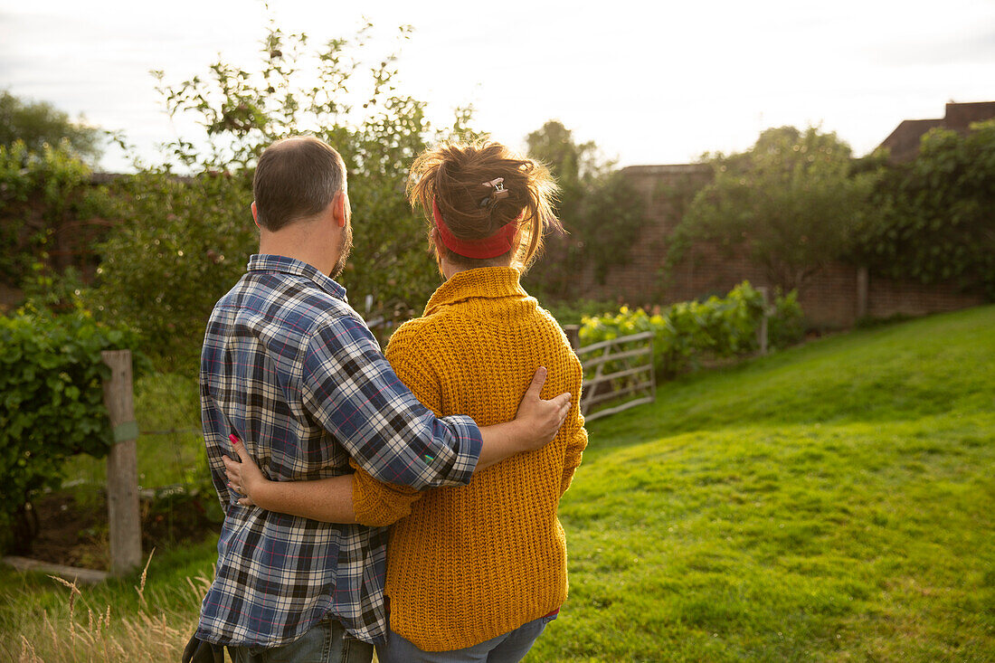 Happy couple hugging in sunny summer garden