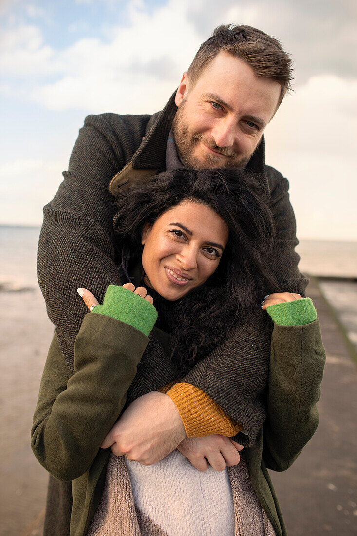 Happy couple in winter coats hugging