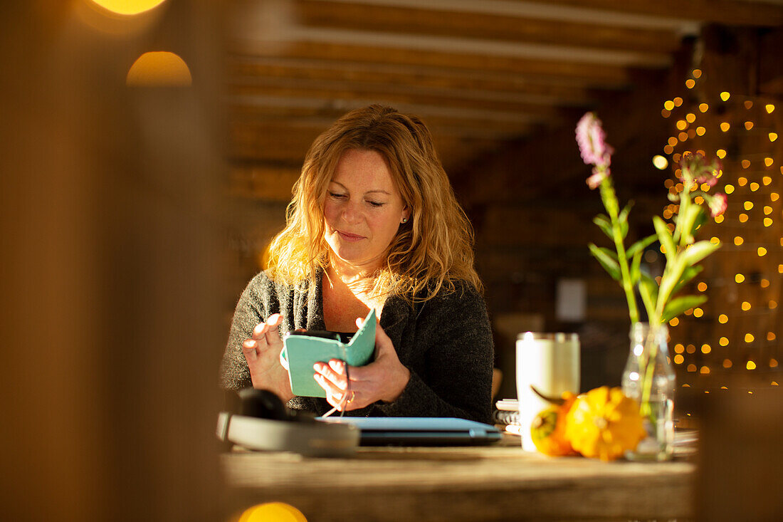 Businesswoman using smart phone at cafe table