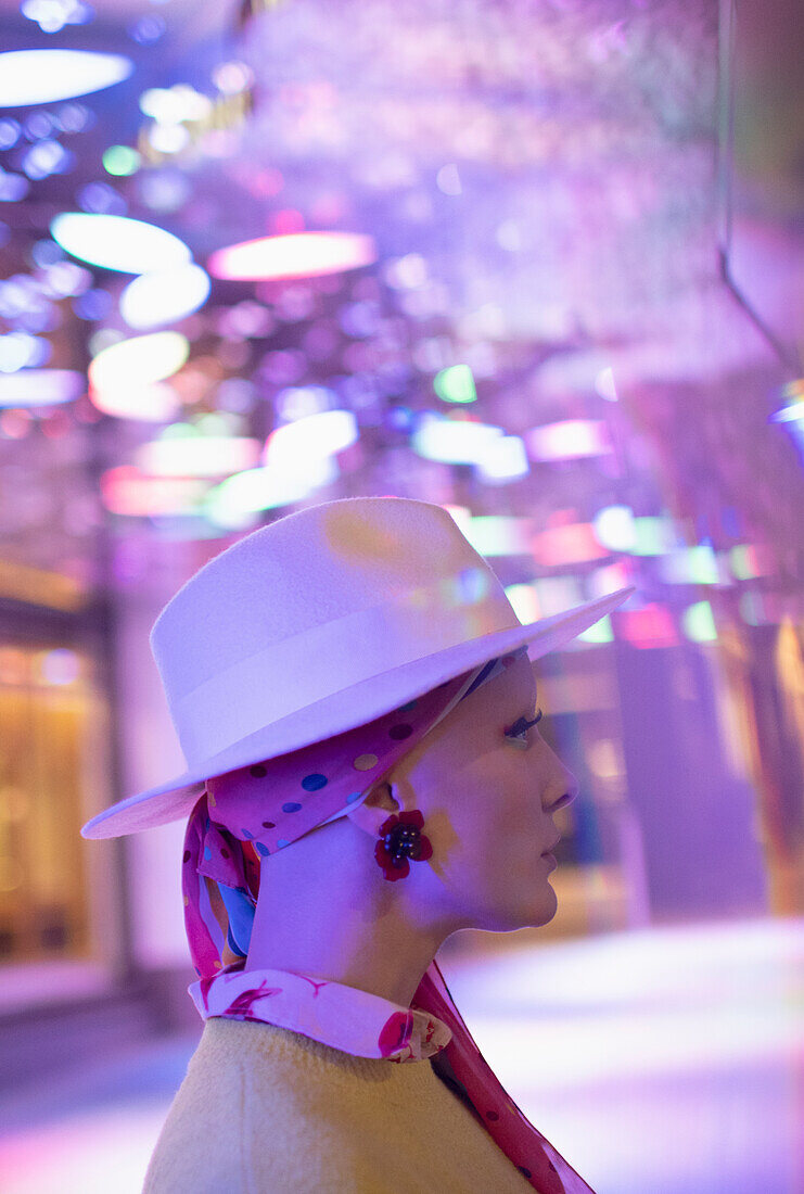 Woman in fedora under neon lights