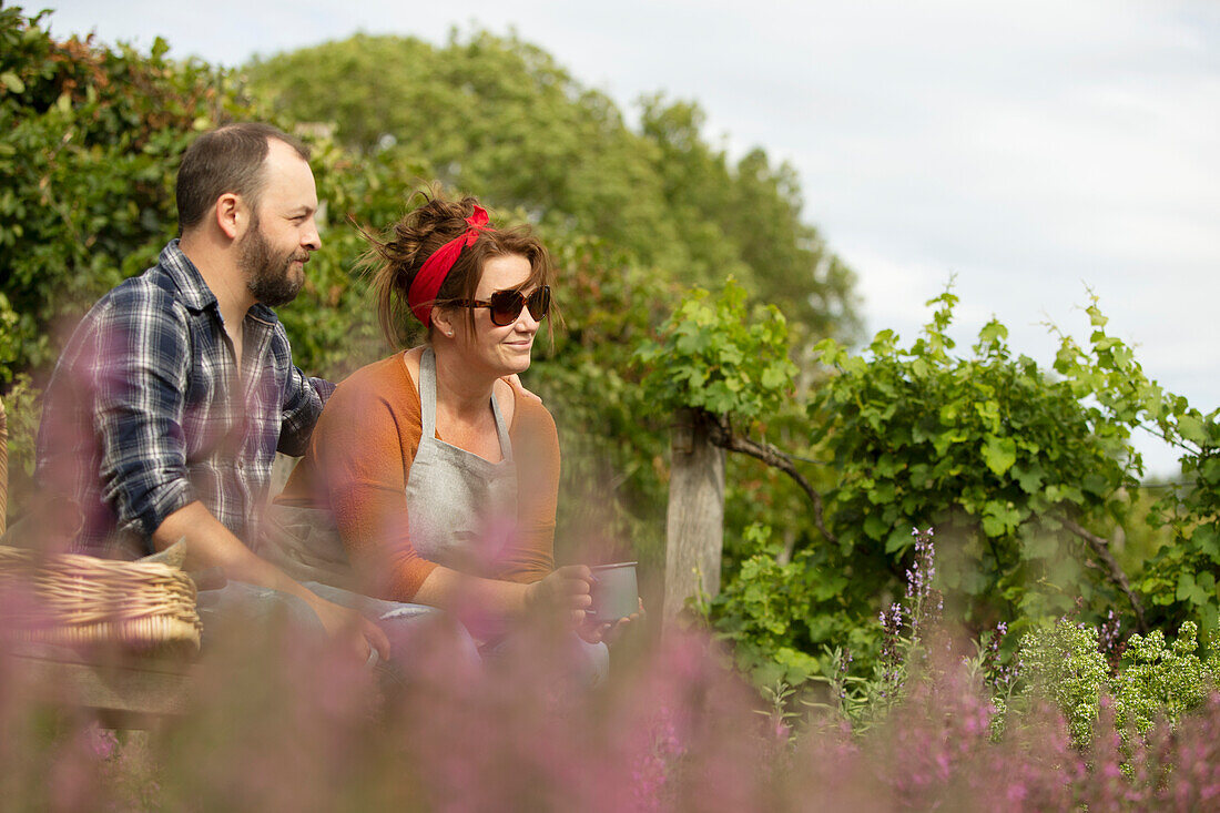 Couple relaxing with tea on sunny summer bench