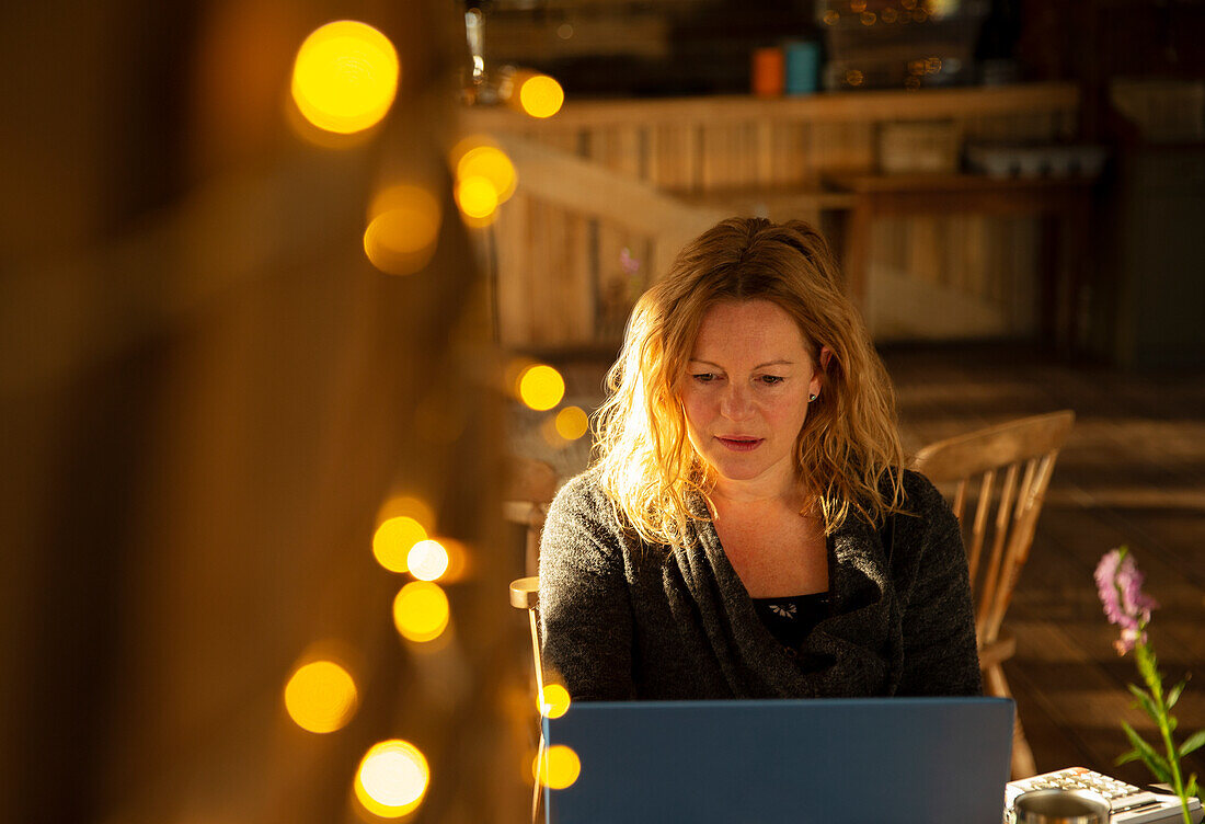 Focused businesswoman working on laptop in cafe