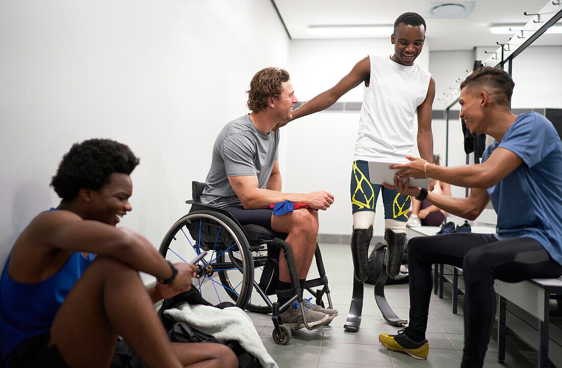 Happy male amputee and paraplegic athletes in locker room