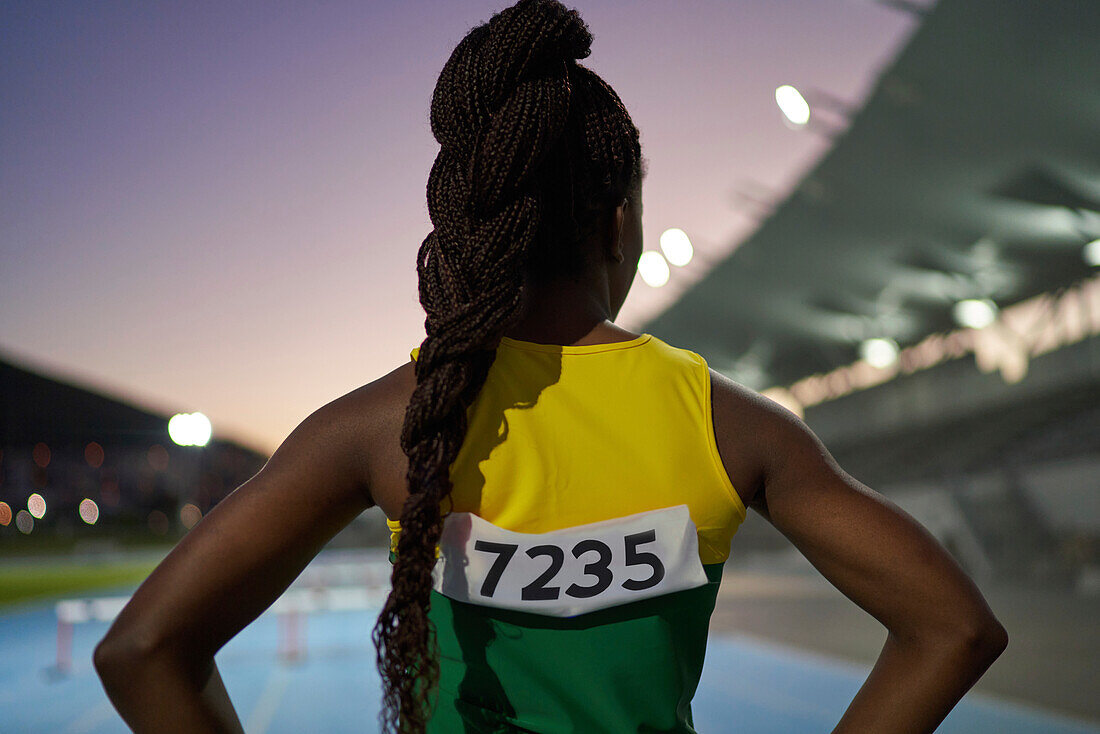 Female athlete with long black braids in stadium