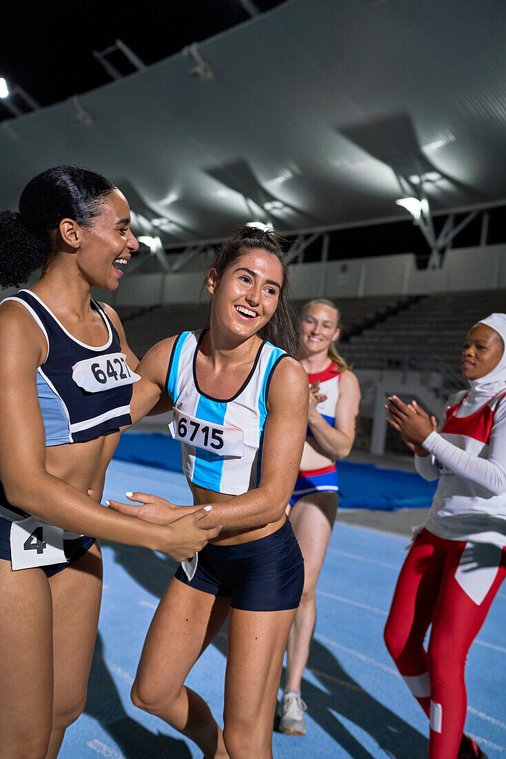 Happy track and field relay athletes celebrating on track