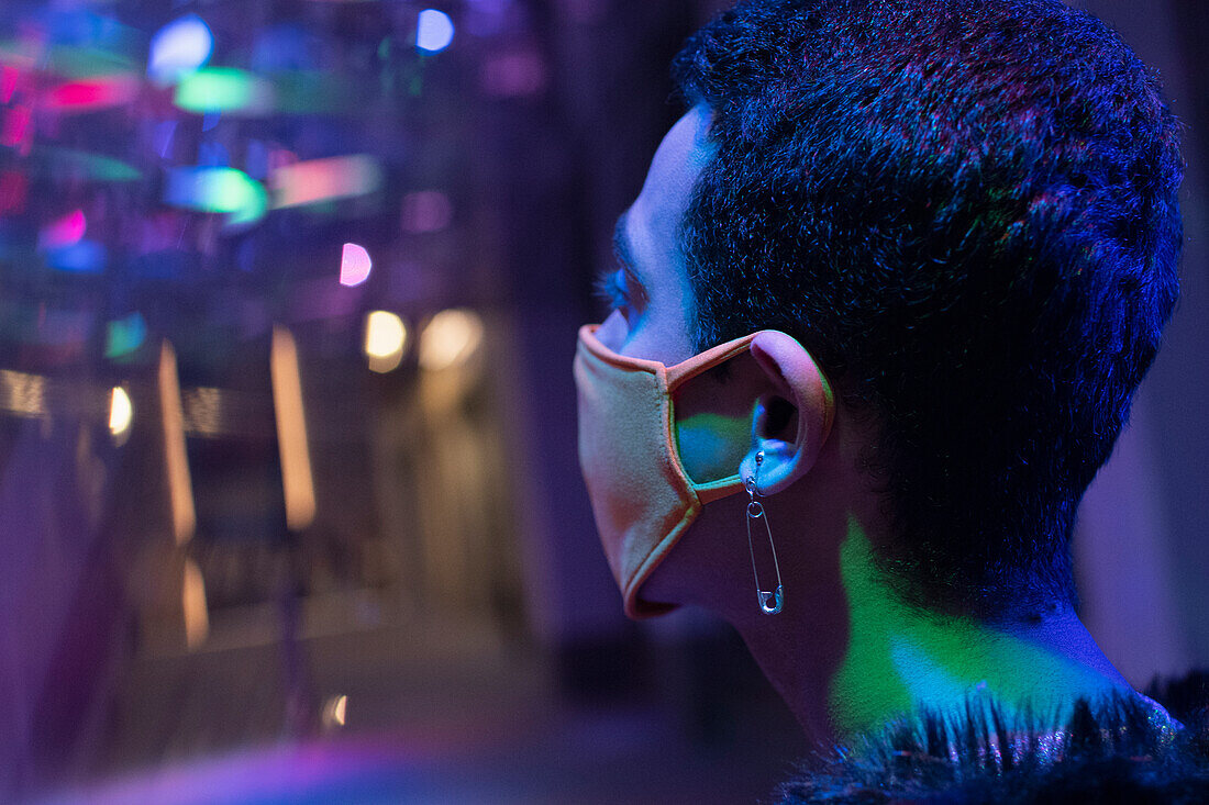Young man wearing face mask in nightclub