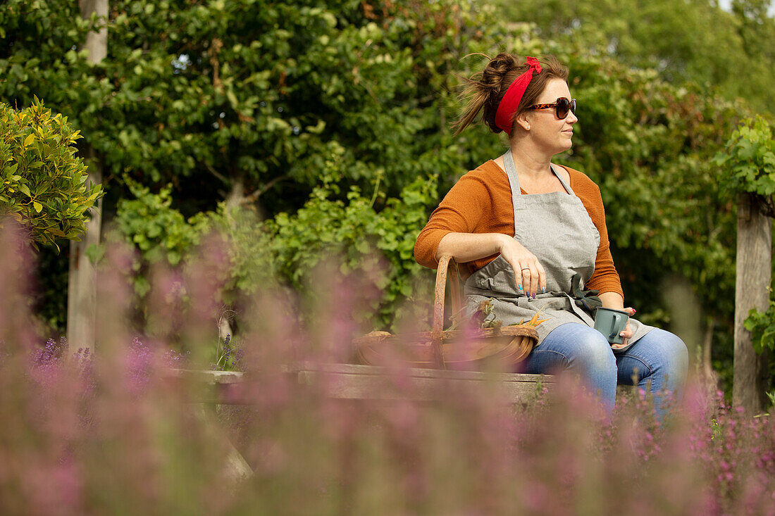 Woman in sunglasses taking a break from gardening