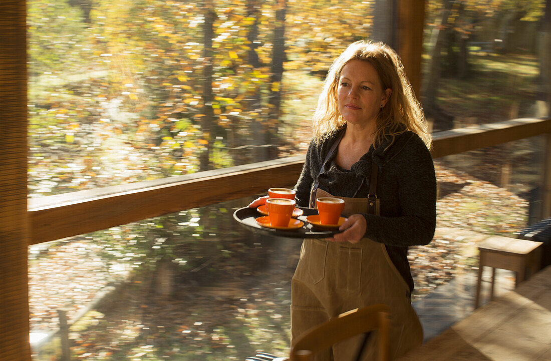 Barista carrying coffee on tray