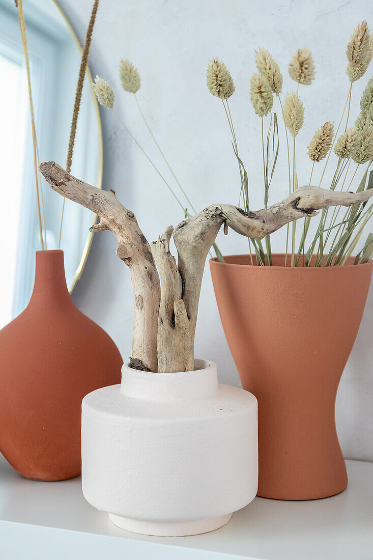 Vases holding driftwood and dried flowers painted with homemade chalk paint