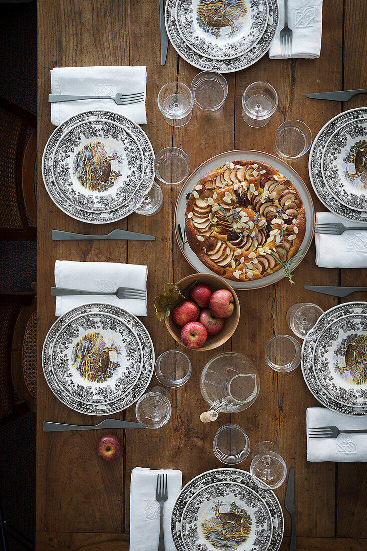 Gedeckter Holztisch mit Vintage Geschirr und Apfelkuchen