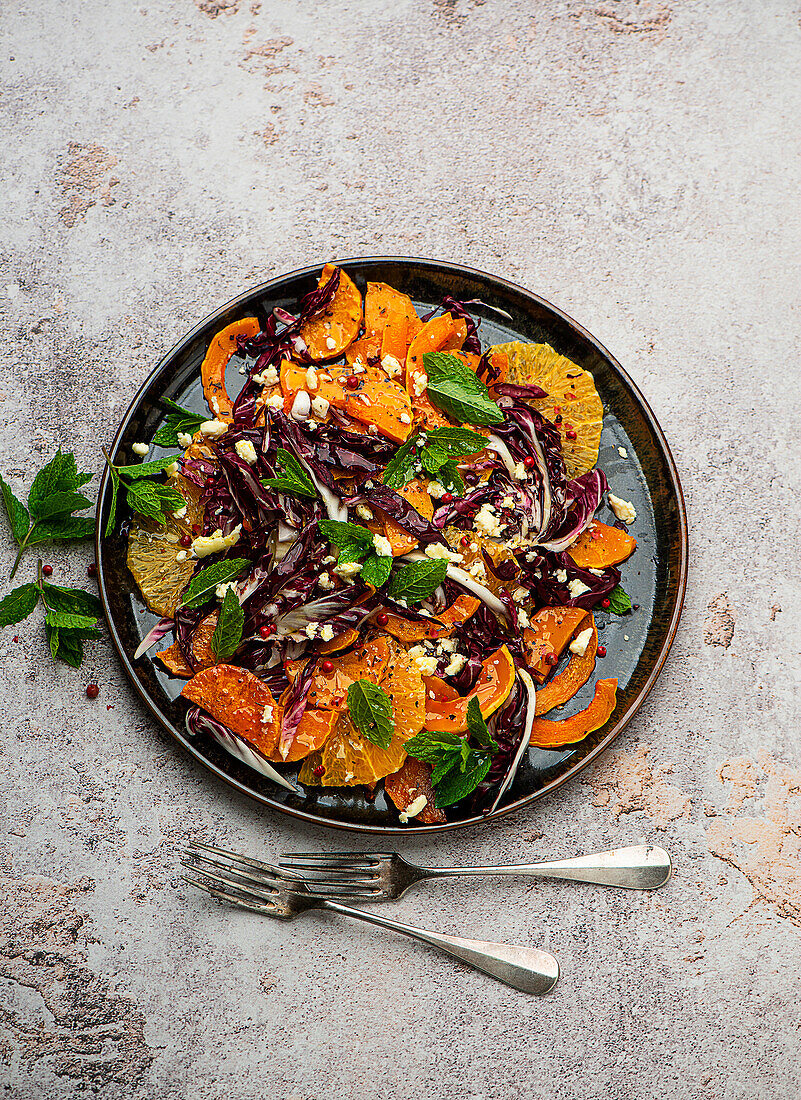 Roasted pumpkin salad with segmented orange slices and goat cheese