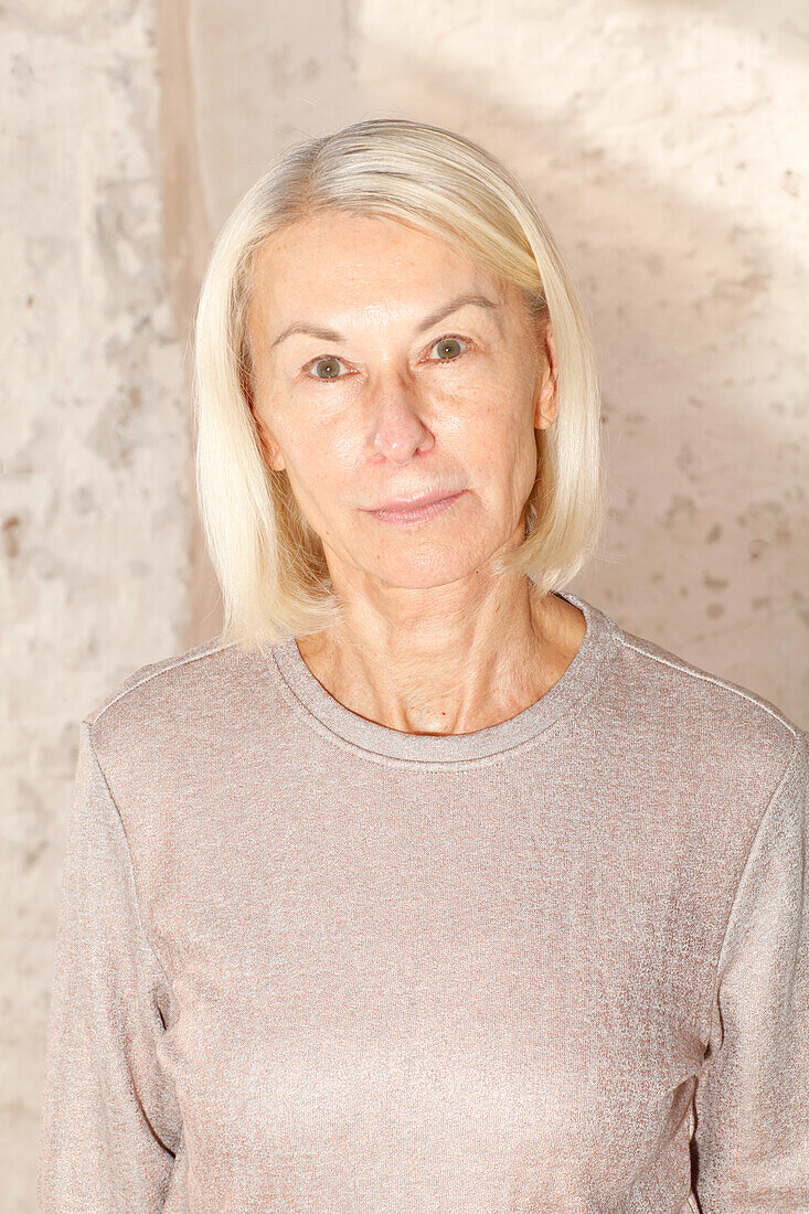 An older woman wearing a grey jumper