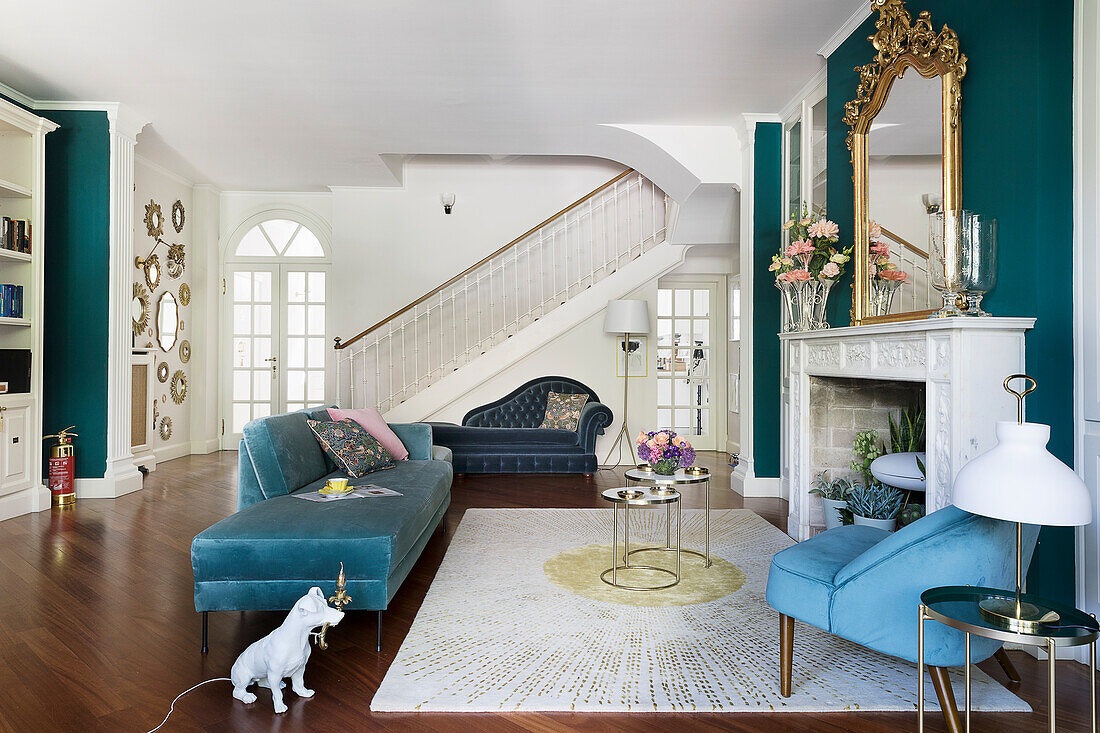 Elegant seating area with upholstered furniture and fireplace: staircase in the background