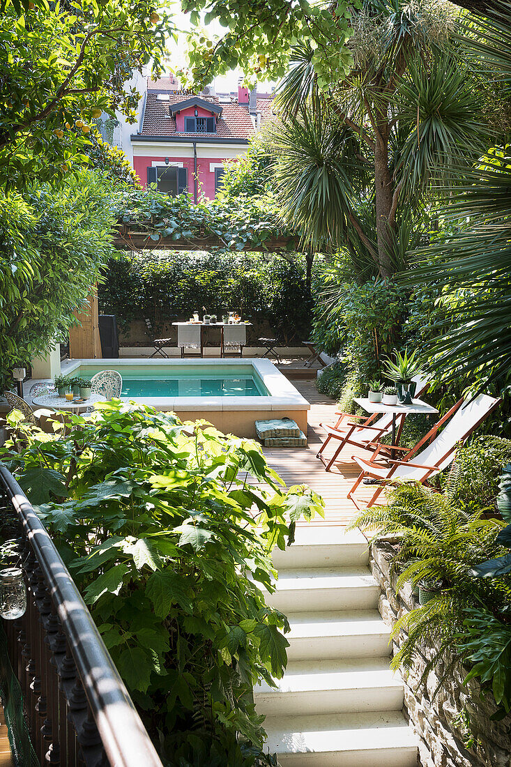 Stairs leading to the terrace with deck chairs and swimming pool