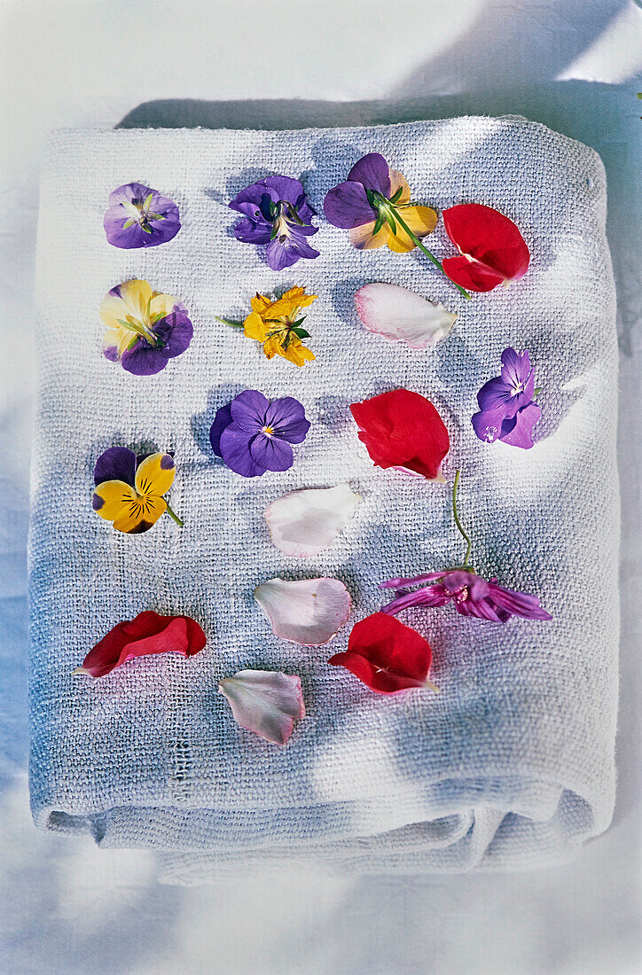 Edible flower petals on a linen blanket