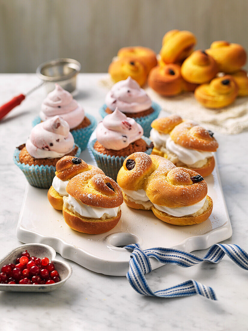 Saffron buns with whipped cream and almond paste, muffins with lingonberries