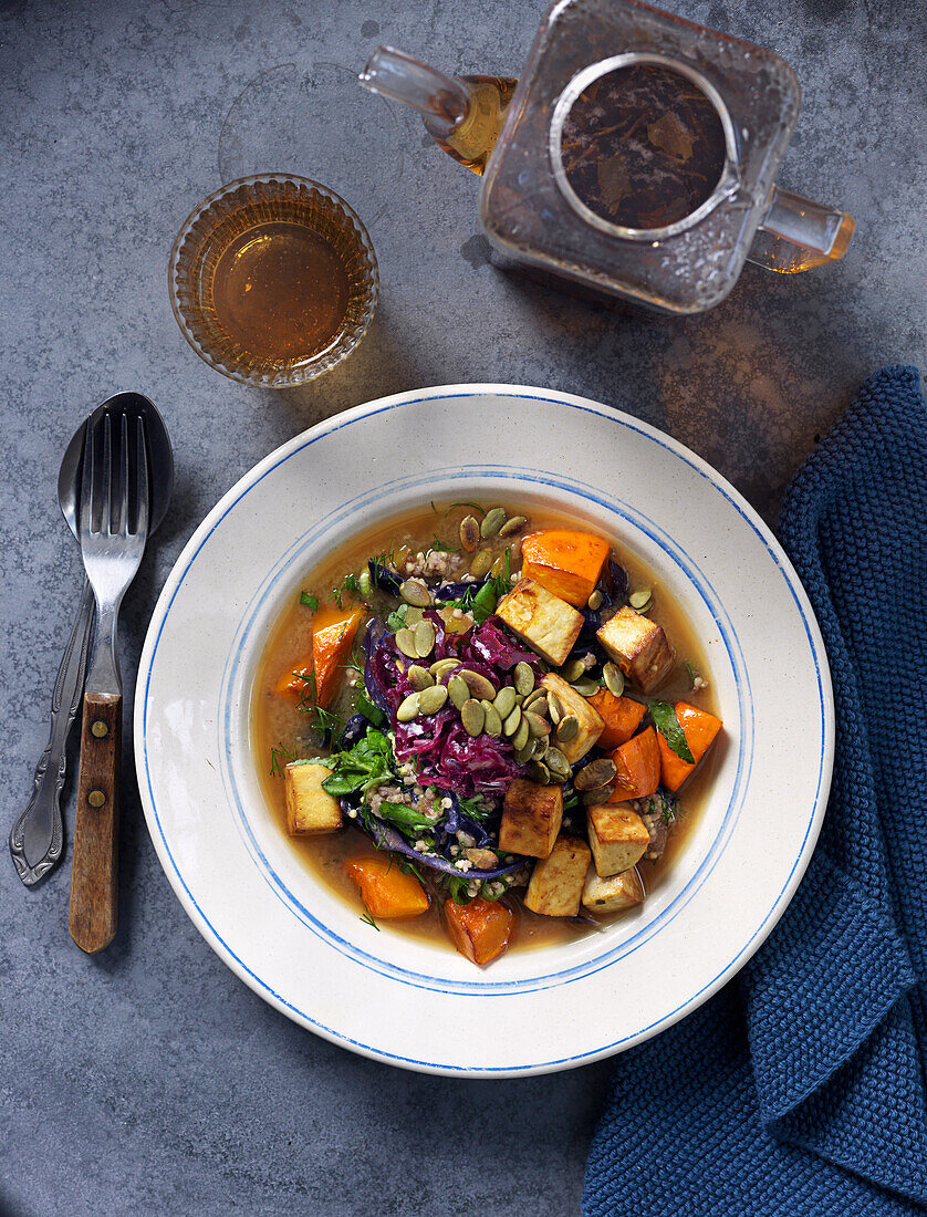 Vegetarian soup with butternut pumpkin, cabbage, herbs, pumpkin seeds and tofu
