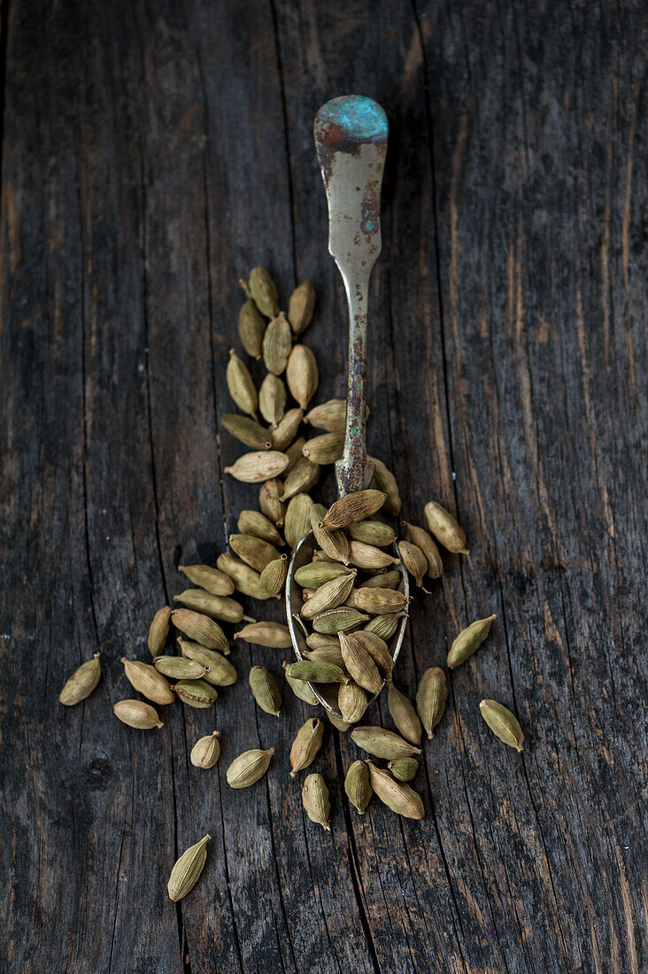 Cardamon seeds on a wooden background