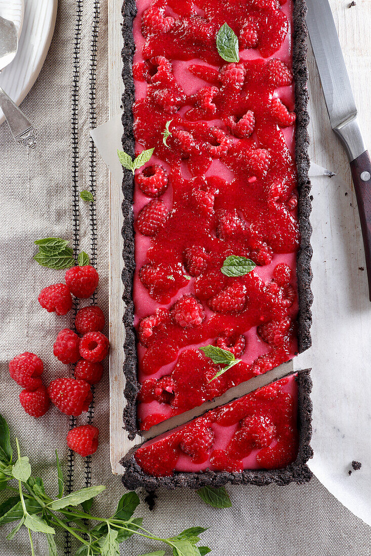 Tart on a chocolate base with raspberry cream and fresh raspberries