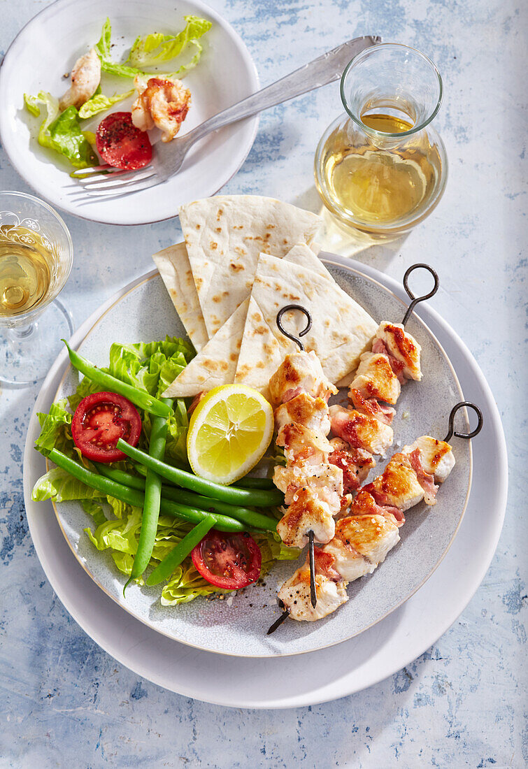 Chicken shashlik with striped bacon and vegetable salad