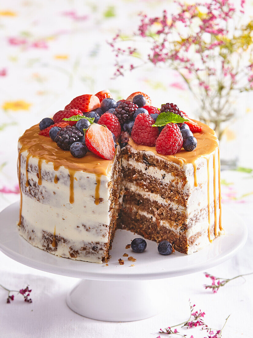 Karottenkuchen mit Salzkaramell und Sommerbeeren, angeschnitten