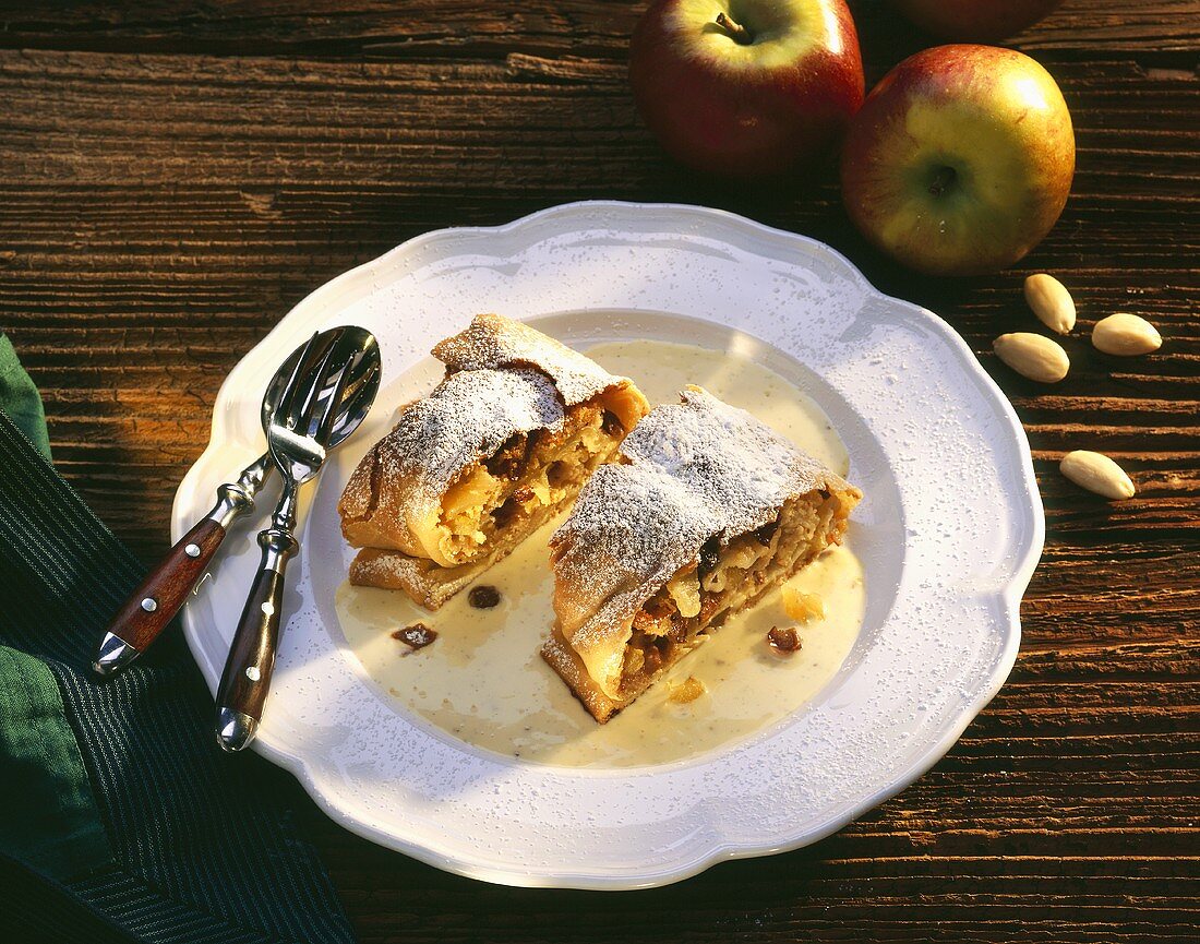 Two pieces of apple strudel with custard on plate
