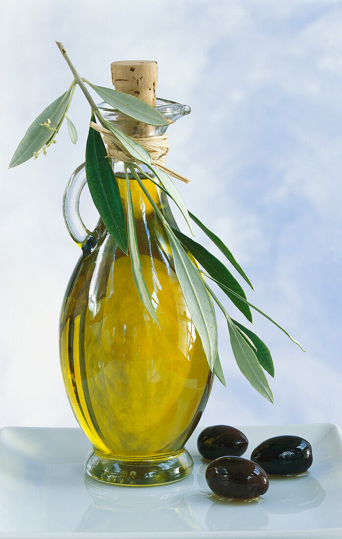 Flasche Olivenöl mit Olivenzweig und Oliven