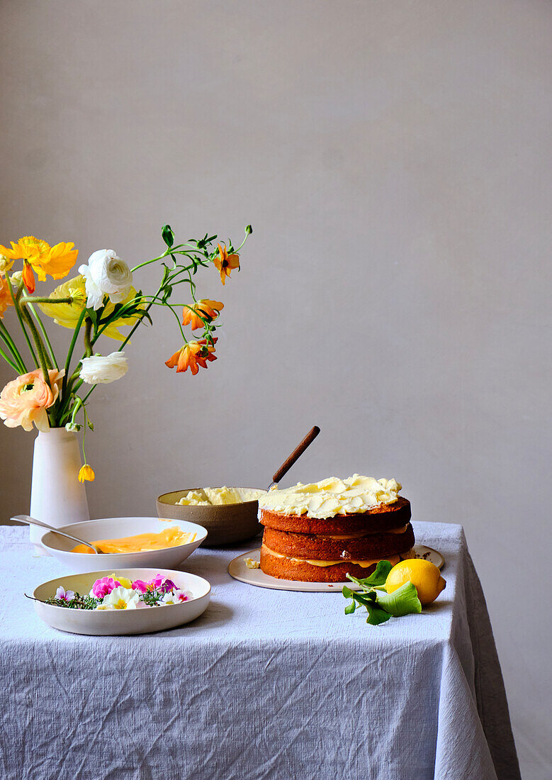 A layer cake with lemon curd, frosting and flowers