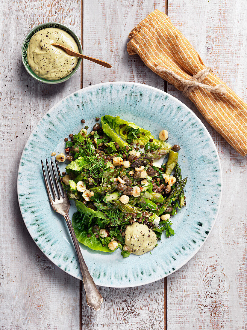 Salad with hazelnuts, asparagus, dill, dressing, lentils and capers