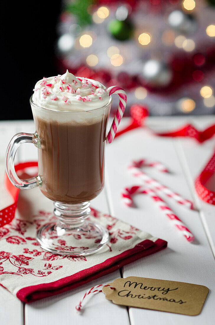 Heiße Schokolade serviert mit Zuckerstange zu Weihnachten