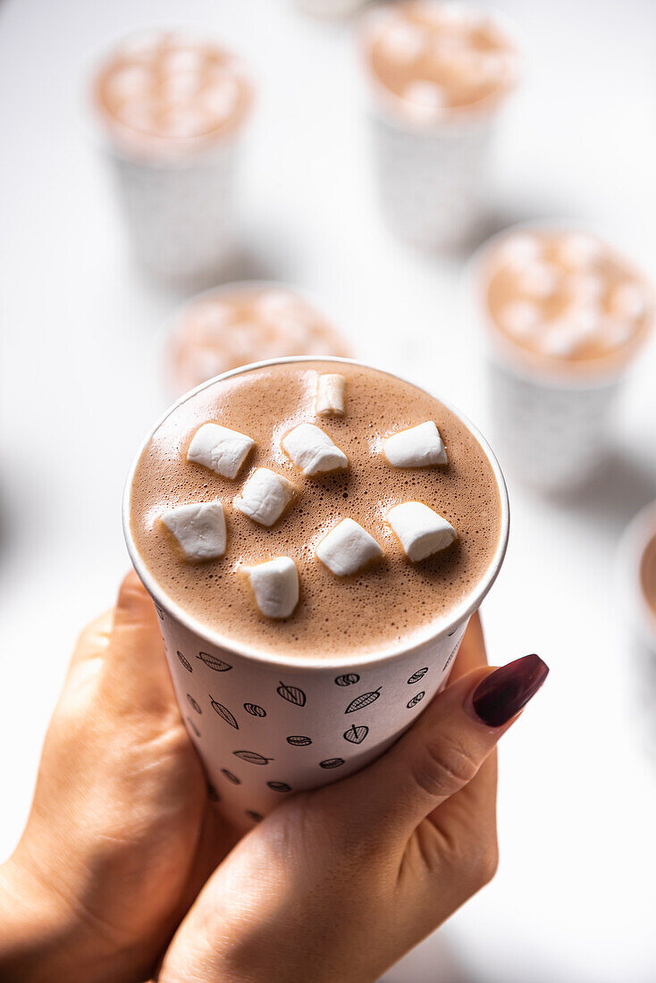 hands holding a cup of hotchocolate with marshmallows
