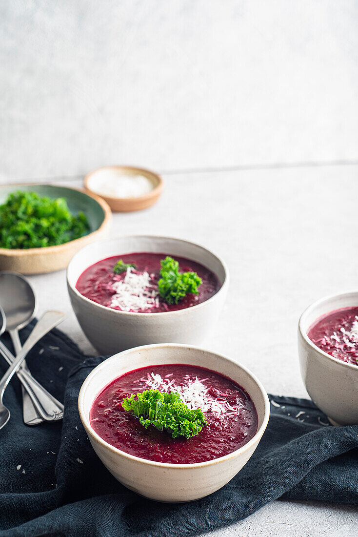 Beetroot soup with parmesan cheese and kale to decorate