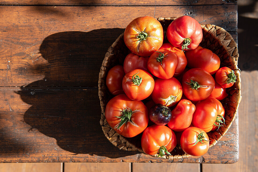 Bio-Tomaten in Korb auf Holztisch