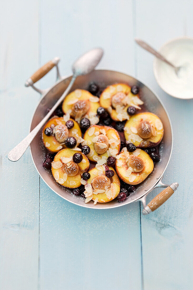 Baked peaches with almonds, blueberries and marzipan balls