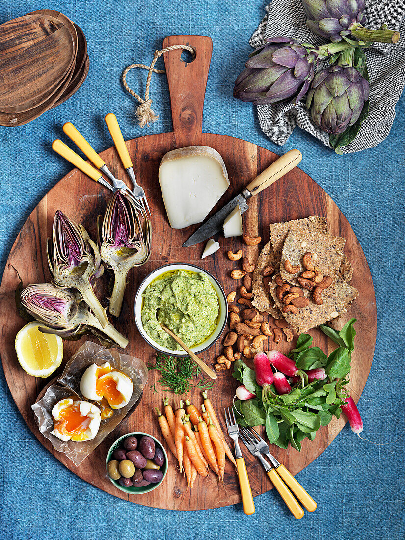 Vorspeisenplatte mit Gemüse, Oliven, Käse, Eiern, Nüssen und Avocadodip