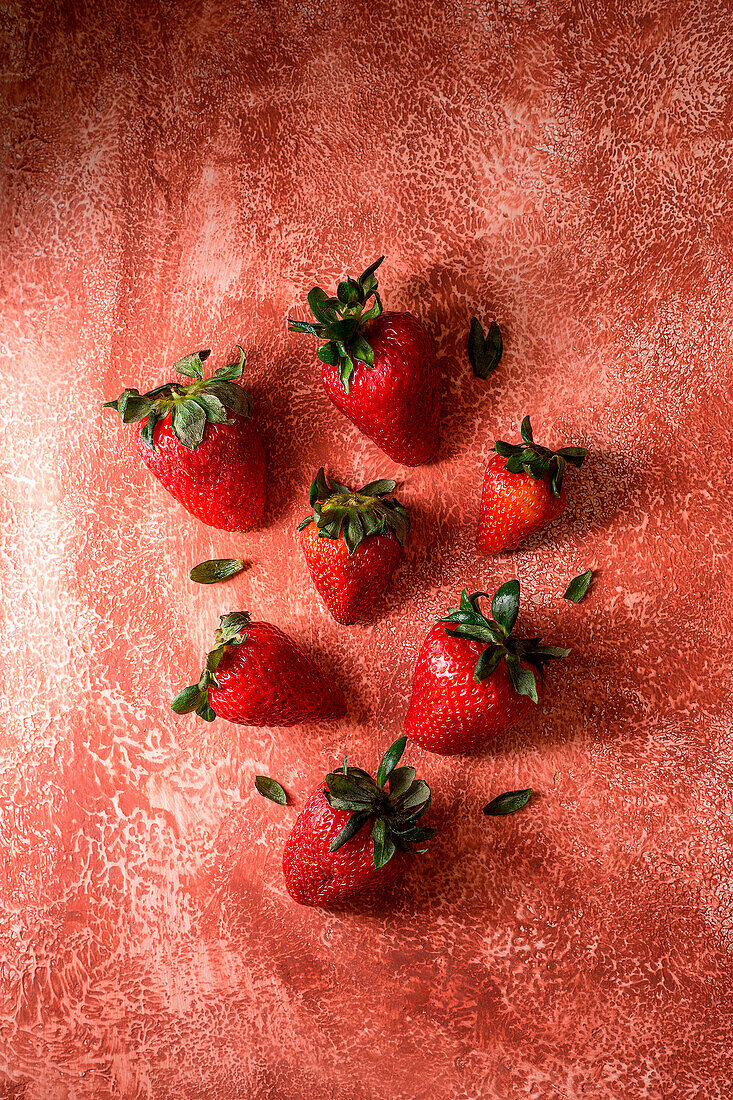 Fresh strawberries on a brick-red background