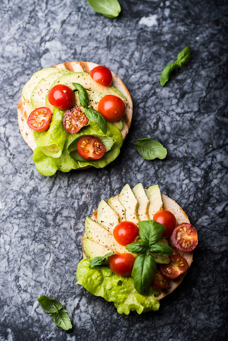 Bagels mit Avocado, Kirschtomaten und Basilikum