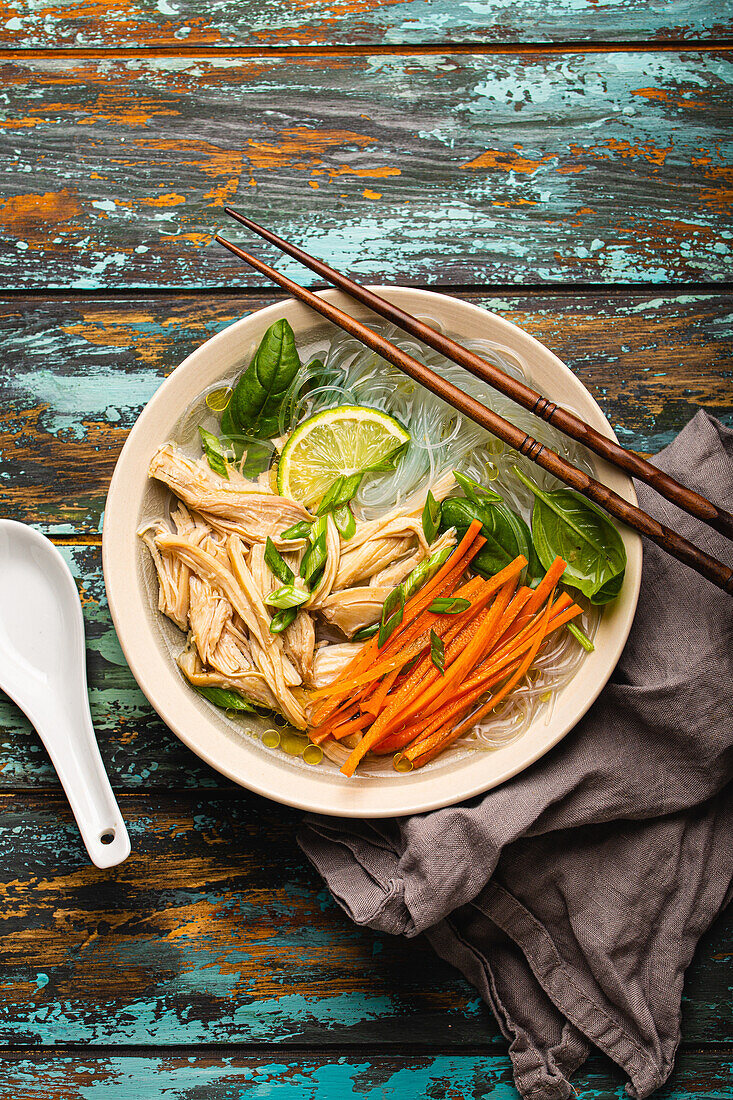 Asian soup with rice noodles, chicken and vegetables