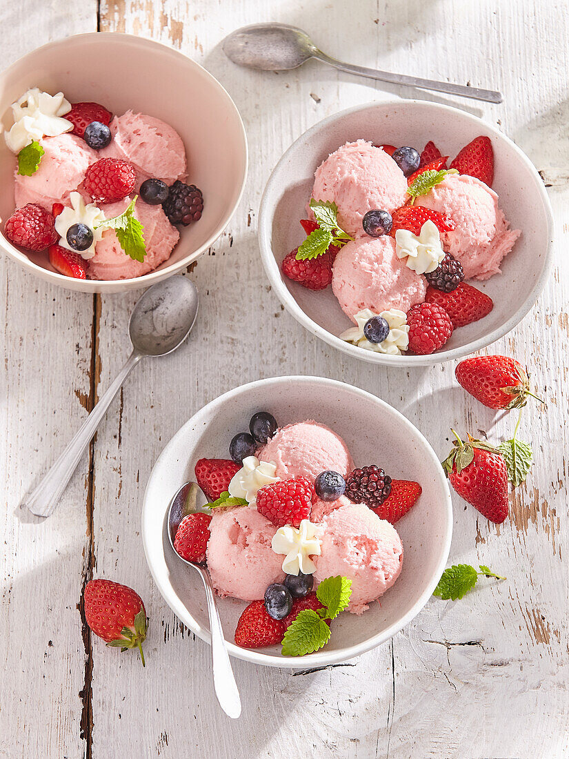 Homemade ice cream with forrest berries and whipped cream