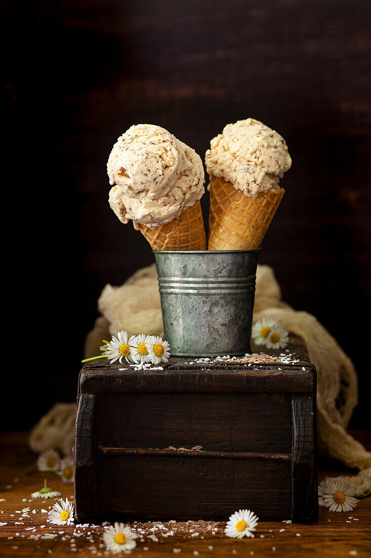 Two waffling cones holding scoops of coconut ice cream