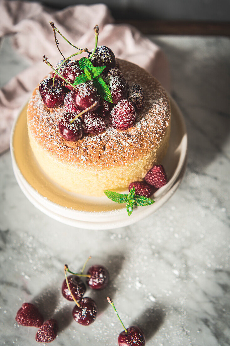 A homemade Japanesse souffle cheesecake served with fresh cherries