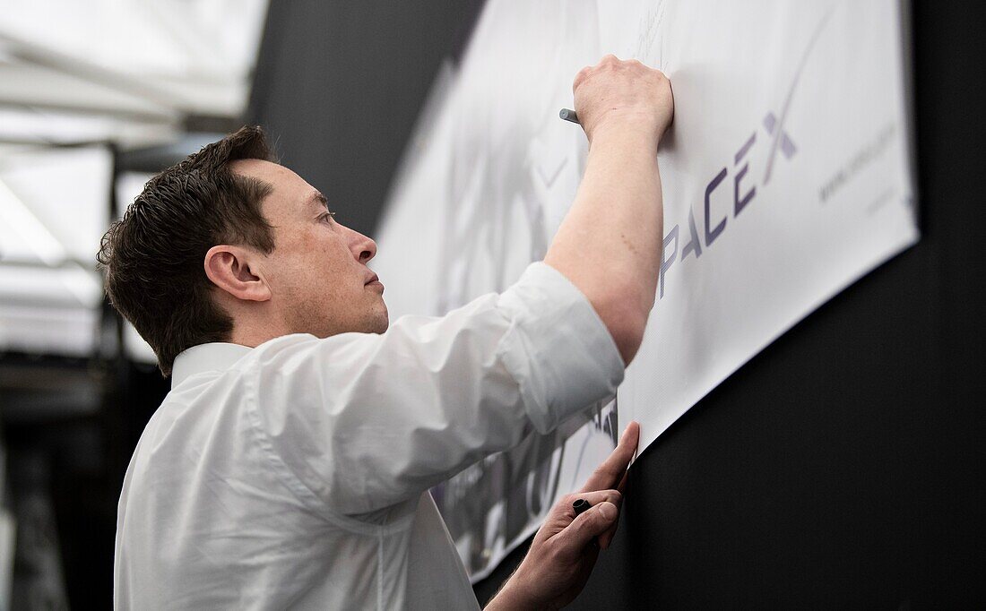 Elon Musk signing a banner