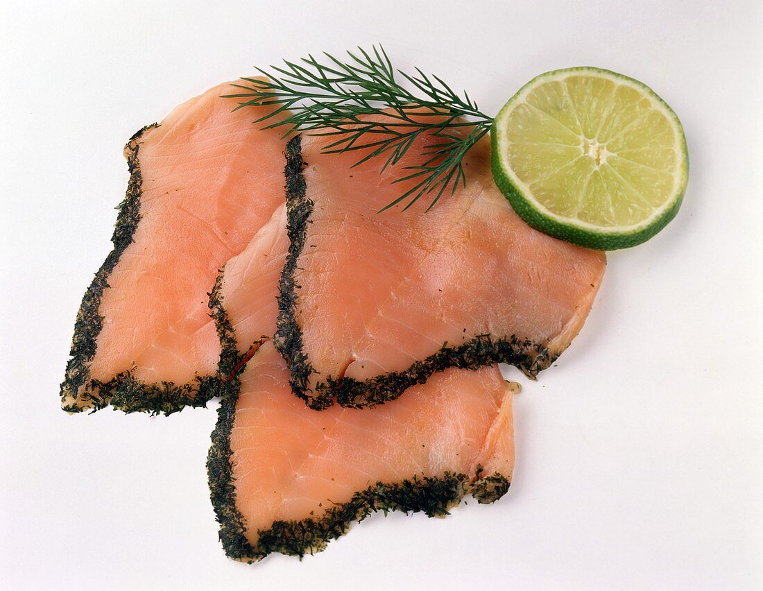 Three slices of Graved Lachs, garnished with dill, lime slice