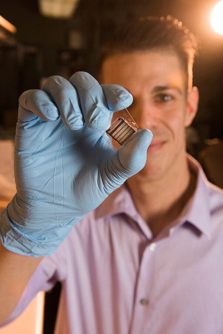 NASA researcher holding a perovskite-based solar cell
