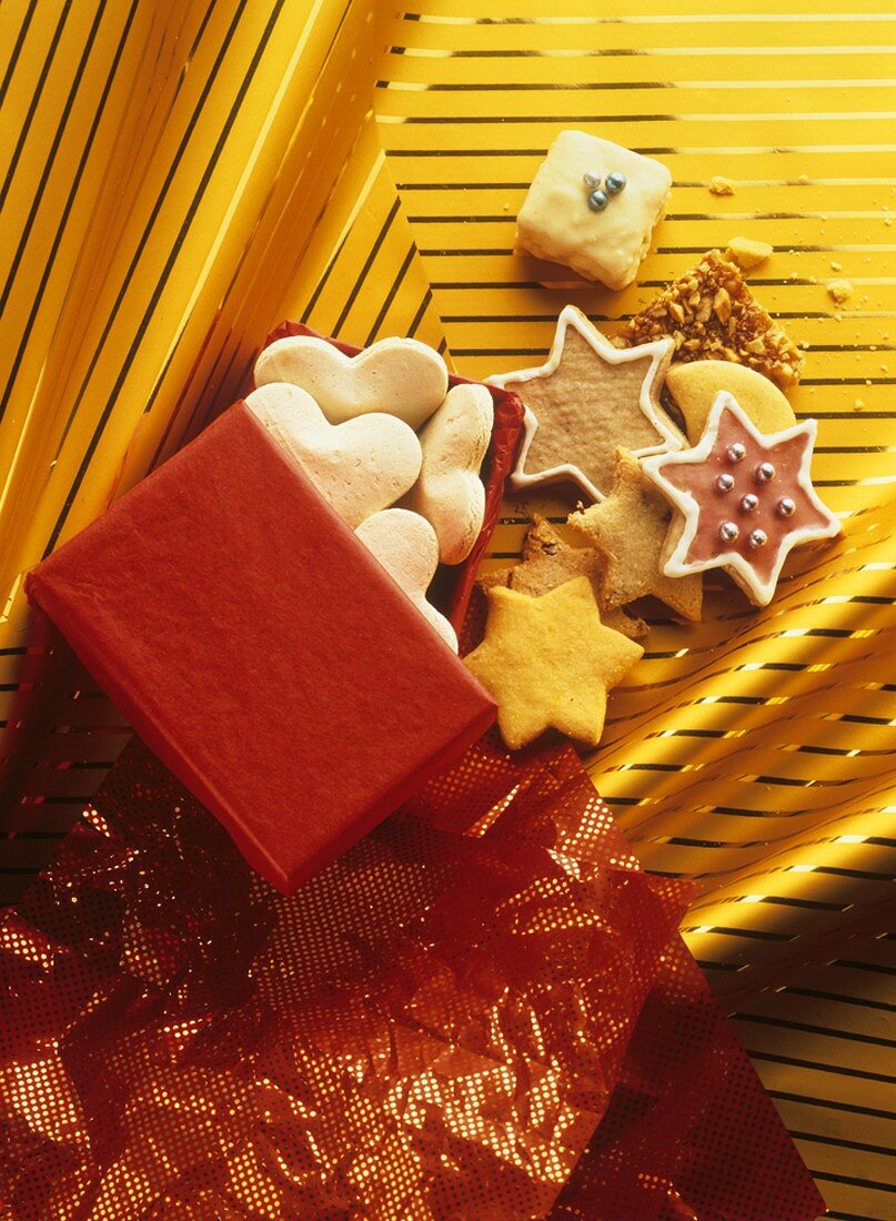 Weihnachtsplätzchen fallen aus roter Geschenkschachtel