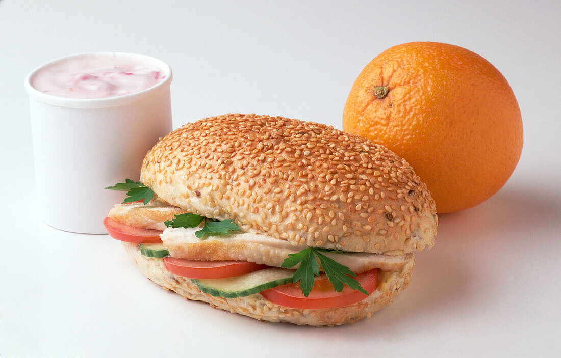 Orange, chicken sandwich and yoghurt