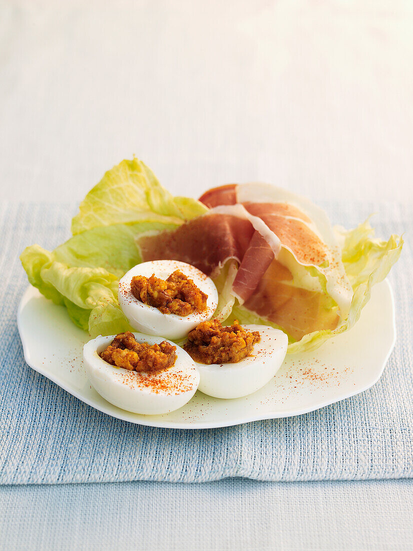 Curried eggs served with lettuce and parma ham
